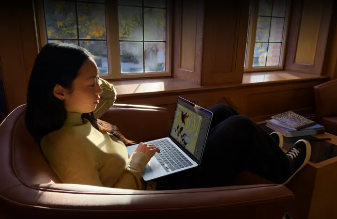 一个人坐在椅子上使用 MacBook Air。