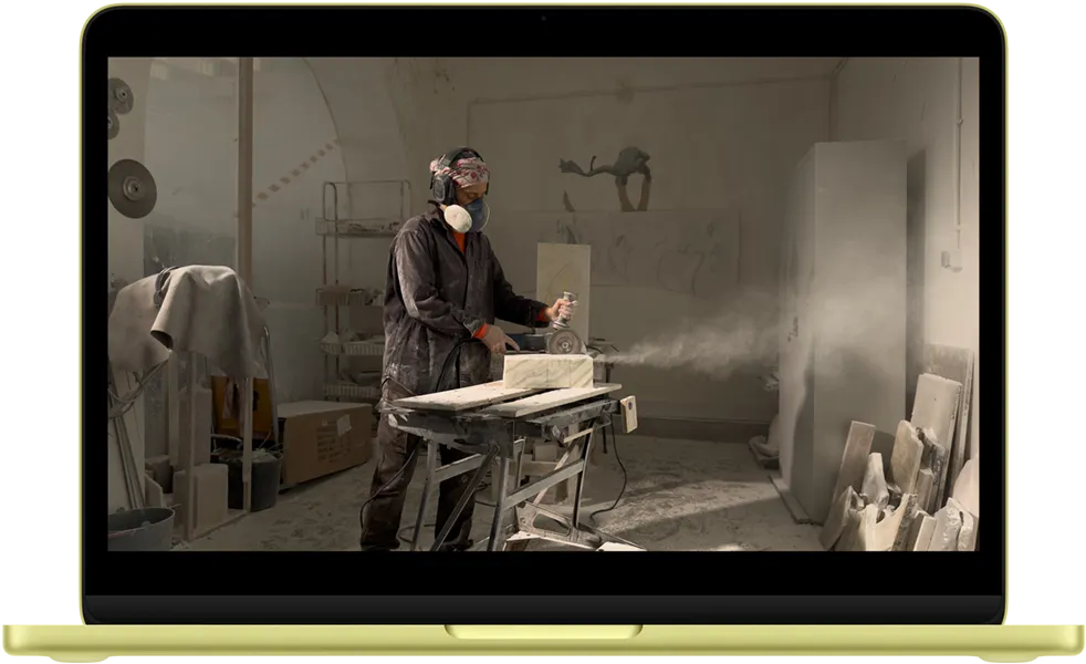 柑橘黄色 MacBook Neo，屏幕显示一段视频的场景。