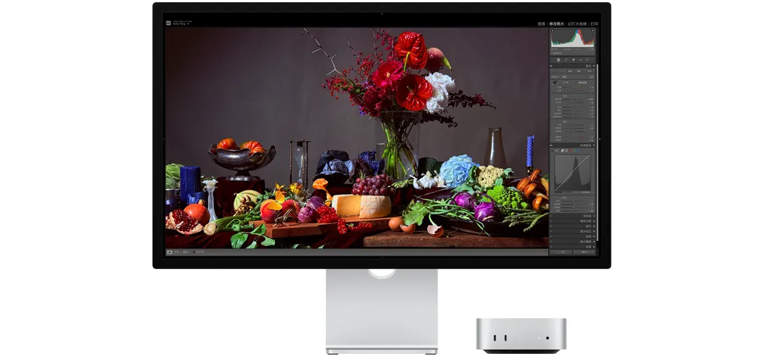 深色背景下一张桌子的高对比度图像，桌上摆放着各种盘装食物和一束花，展示原彩显示技术如何调整色温。