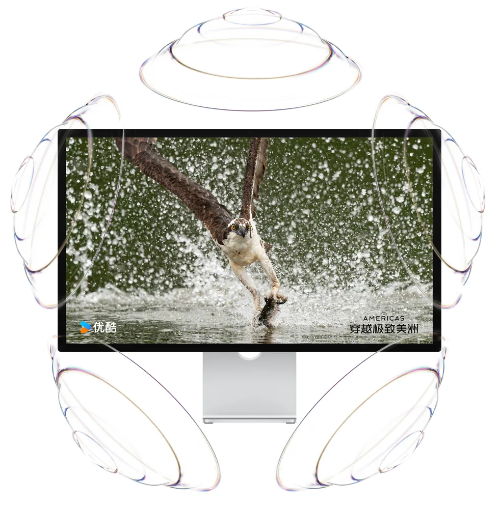 Studio Display 的屏幕上显示优酷的《穿越极致美洲》纪录片，周围环绕着六个透明的扬声器。